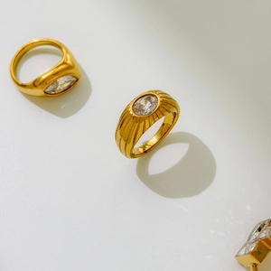 Macro view of gold-plated rings showing marquise cut zircon and textured band detail