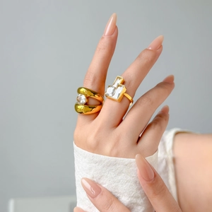Detail of 18K gold plated titanium rings with round and geometric zircon stones