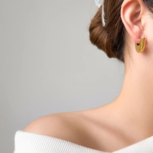Minimalist gold U-shaped hollow earrings in geometric design on female model's ear