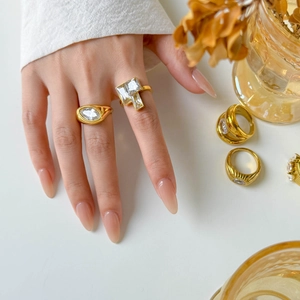 Detailed view of layered 18K gold plated titanium rings with marquise and square zircons