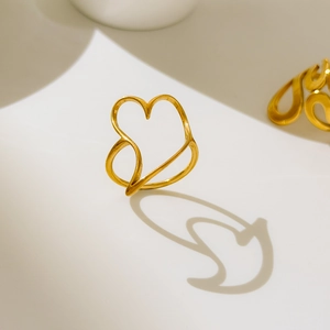 Macro view of a 18K gold plated heart ring with an artistic hollow curved line design