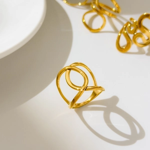 Detail shot of hollowed-out curved golden ring featuring a polished crossover line design