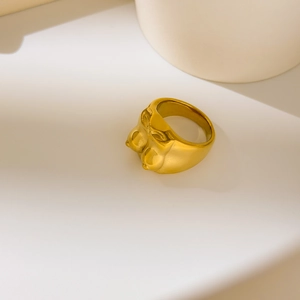 Macro detail of artistic 18K gold plated female body sculpture ring with matte finish