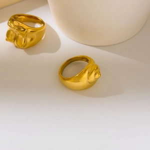 Detail shot of the sculptural body-shaped ring with a polished 18K gold plated finish