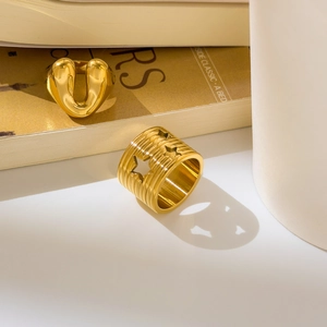Detail of 18K gold-plated rings with hollow star pattern and textured surface detail