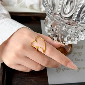 Detail of 18K gold-plated stainless steel hollow heart ring worn on finger