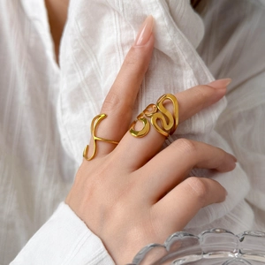 Detailed view of 18K gold plated titanium rings with elegant curved hollow heart design