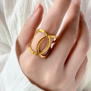 Detailed view of polished 18K gold plated geometric ring on model wearing white shirt