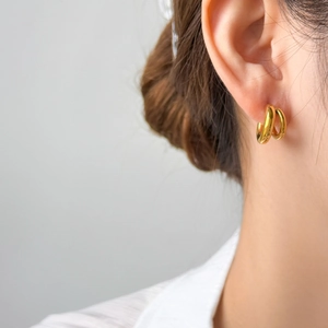 Gros plan de créoles minimalistes bicolores en forme de C plaquées or 18 carats