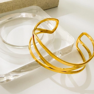 Detailed view of golden triple-layered spiral bangle with polished sleek finish