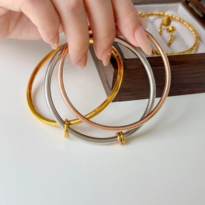 Polished titanium steel screw bangles in gold, silver, and rose gold with metal rings