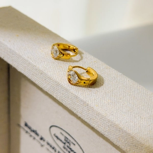 Close-up of a gold-plated stainless steel earring with a brilliant round-cut zircon stone