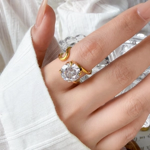 Detailed view of large round zircon stone on wavy gold-plated titanium steel open ring