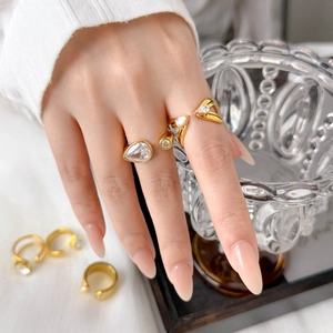 Detail showing 18K gold plated titanium ring with teardrop and round cubic zirconia
