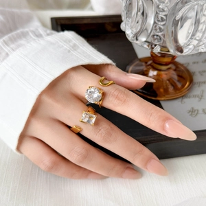 Detailed view of 18K gold plated titanium rings with round and rectangular zircon stones