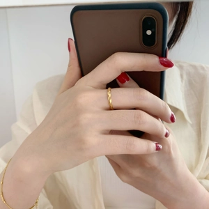 Close-up of golden olive leaf open ring worn on index finger with minimalist style