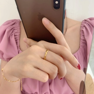 Detailed view of a gold olive leaf open ring and matching thin chain bracelet on a hand