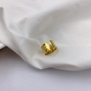 Macro view of wide gold open ring featuring unique hand-hammered textured surface