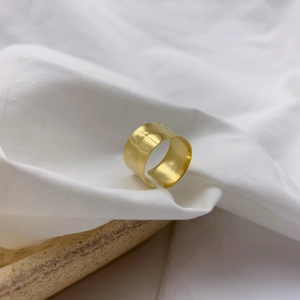 Macro detail of gold hammered texture on wide adjustable open ring for women