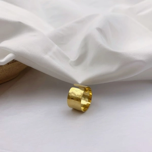 Gold wide hammered adjustable ring with vintage texture on white fabric background