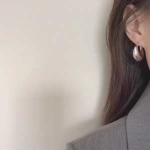 Minimalist silver chunky hoop earrings with a mirror finish worn by a model