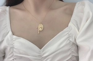 Détail du médaillon ovale Vierge Marie et pendentif croix dorés sur chaîne fine