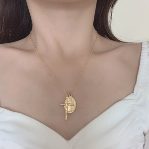 Gros plan du médaillon ovale Vierge Marie et pendentif crucifix sur une chaîne dorée