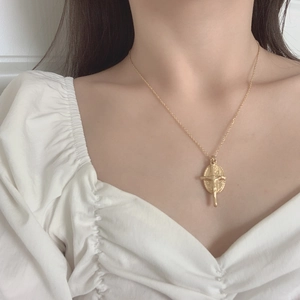 Détail d'un collier médaille ovale Vierge Marie plaqué or avec relief croix porté par un mannequin