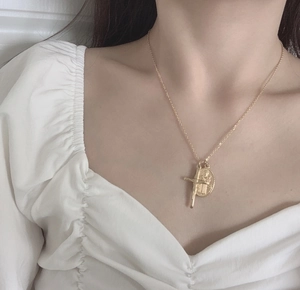 Collier doré avec pendentif médaille Vierge Marie et croix porté par un mannequin