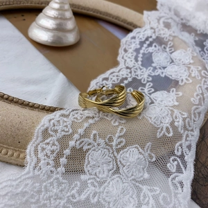 Close-up of golden multi-layer twisted hoop earrings with elegant vintage texture