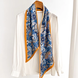Floral printed cotton linen scarf with orange trim styled on a white shirt