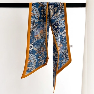Retro blue floral cotton-linen narrow scarf with orange satin border on display