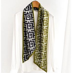 Écharpe en soie à motif géométrique labyrinthe drapée sur une chemise blanche chic