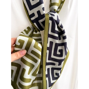 Écharpe en soie à motif géométrique vert olive et bleu marine sur chemise blanche