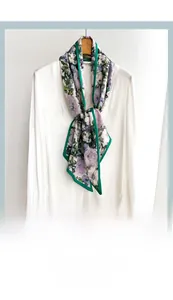 Detail of elegant floral silk scarf with lavender and green patterns on white shirt