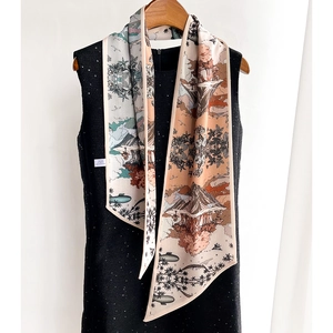 Écharpe longue en soie à imprimé paysage avec une robe en tweed noir sur un cintre en bois