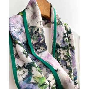 Floral print silk scarf with purple and green patterns on a wooden hanger for professional styling