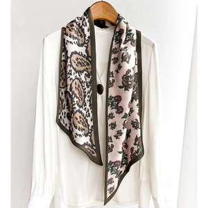 Double-layered silk scarf with leopard and floral patterns on an elegant wooden hanger