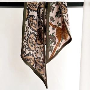 Retro double-sided silk scarf featuring leopard print and floral bow patterns on white wall
