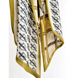 Mustard yellow silk scarf with elegant geometric badge patterns and delicate texture
