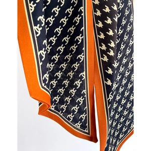 Narrow silk scarf with navy and orange geometric patterns and classic houndstooth design