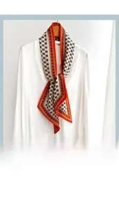 Gros plan d'un élégant foulard en satin beige avec motifs de lettres sur chemise blanche