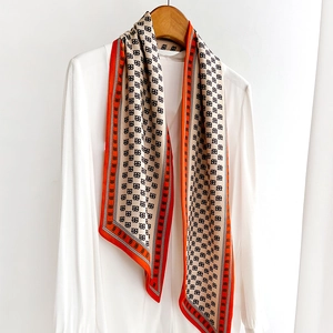 Foulard long à motif géométrique avec bordure orange sur une chemise blanche chic