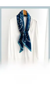 Navy blue silk ribbon scarf with retro circle pattern tied on a white shirt collar
