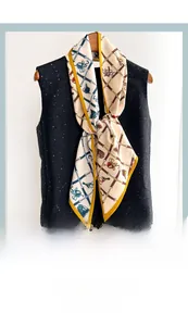 Close-up of narrow silk scarf with equestrian horse bit print on a black sequin top
