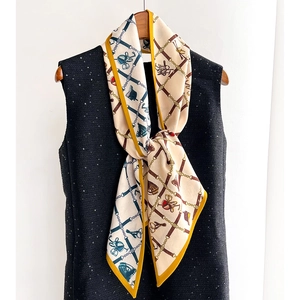 Elegant equestrian print silk scarf with horsebits and yellow border on black tweed