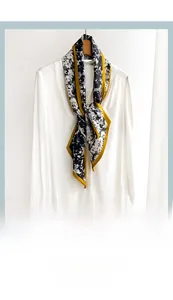 Detailed shot of a black and white floral skinny scarf tied on a white shirt collar