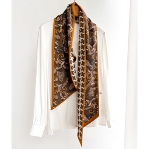 Silk-like scarf with paisley and houndstooth pattern on a white shirt and wooden hanger