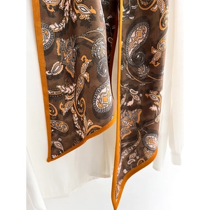 Fashionable paisley print long silk scarf with orange borders on white shirt