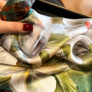 Silk square scarf with lily floral print showing soft texture and glossy finish